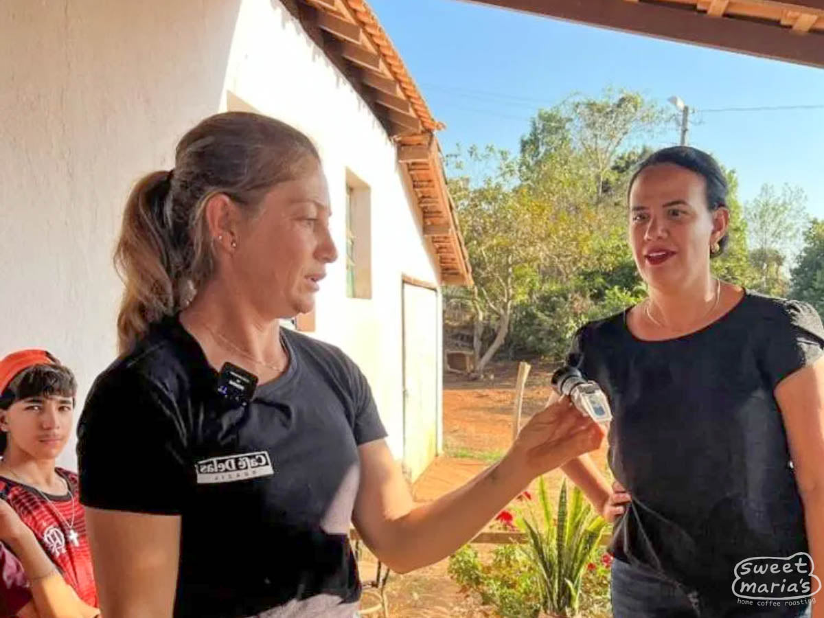 Dalila Vasconcelos (left) holds up a refractometer for measuring sweetness (in "brix"). 