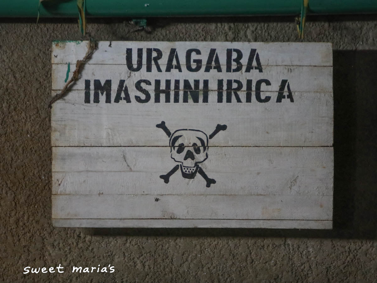 A warning sign at the Kibingo washing station to be careful near the machinery!