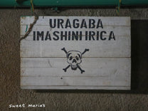 A warning sign at the Kibingo washing station to be careful near the machinery!