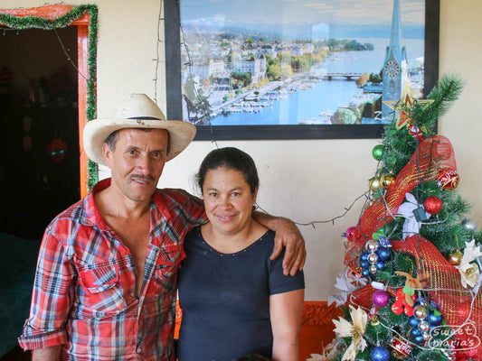 Luz Eleny and husband Don Ruben pose for a photo next to their Christmas tree on a 2017 visit to their green coffee farm on the steep slopes of Caicedo, Colombia.