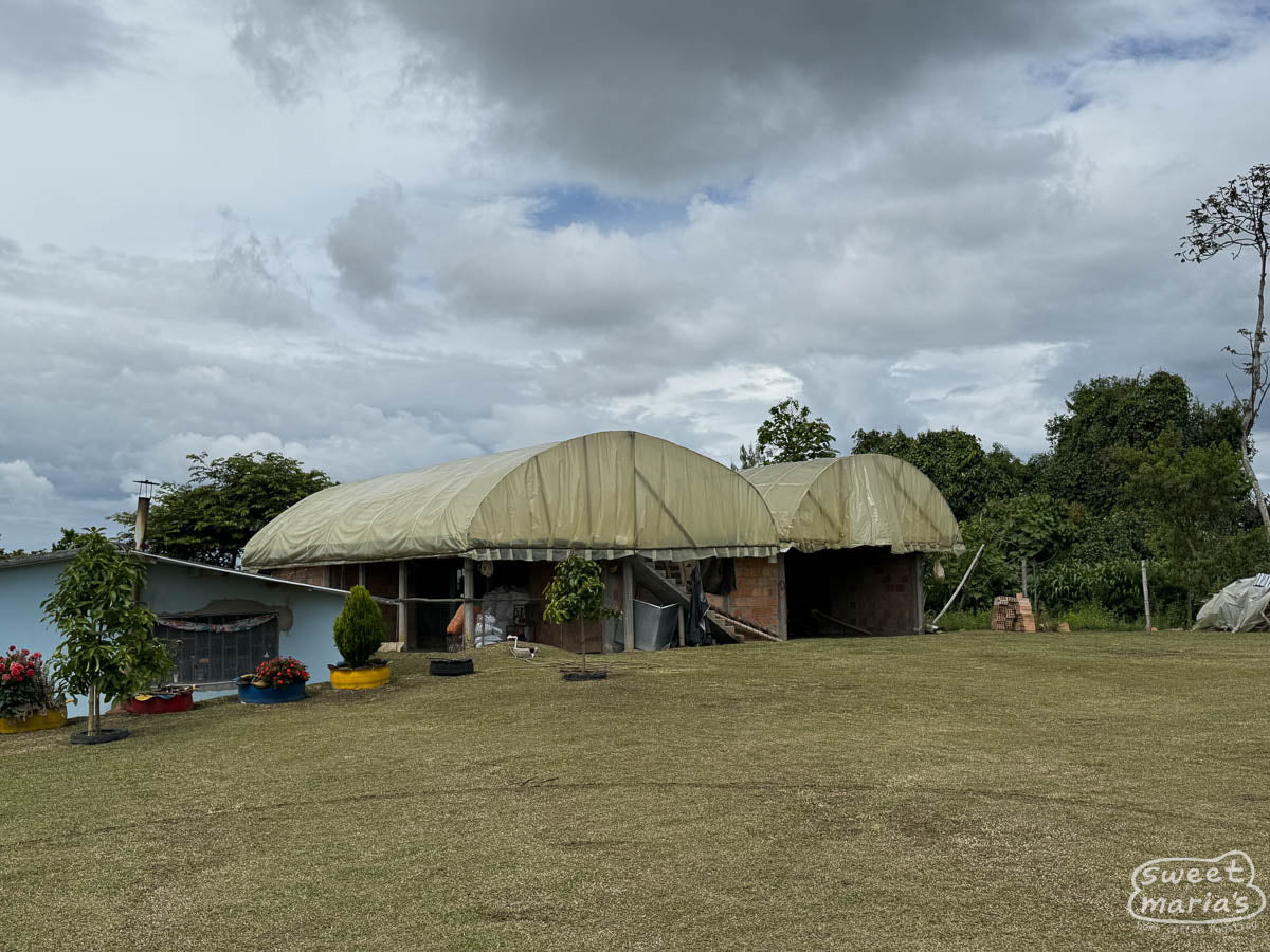 Covered parabolic coffee drying rooms built above homes in Pitalito region.