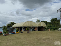 Covered parabolic coffee drying rooms built above homes in Pitalito region.