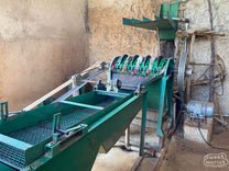 Workers sift through wet process coffee for defects while the coffee dries on raised beds at Gerba Dogo site, Guji.