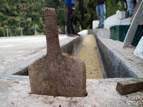 A wooden paddle perched at the far end of a coffee washing channel in Huehuetenango.