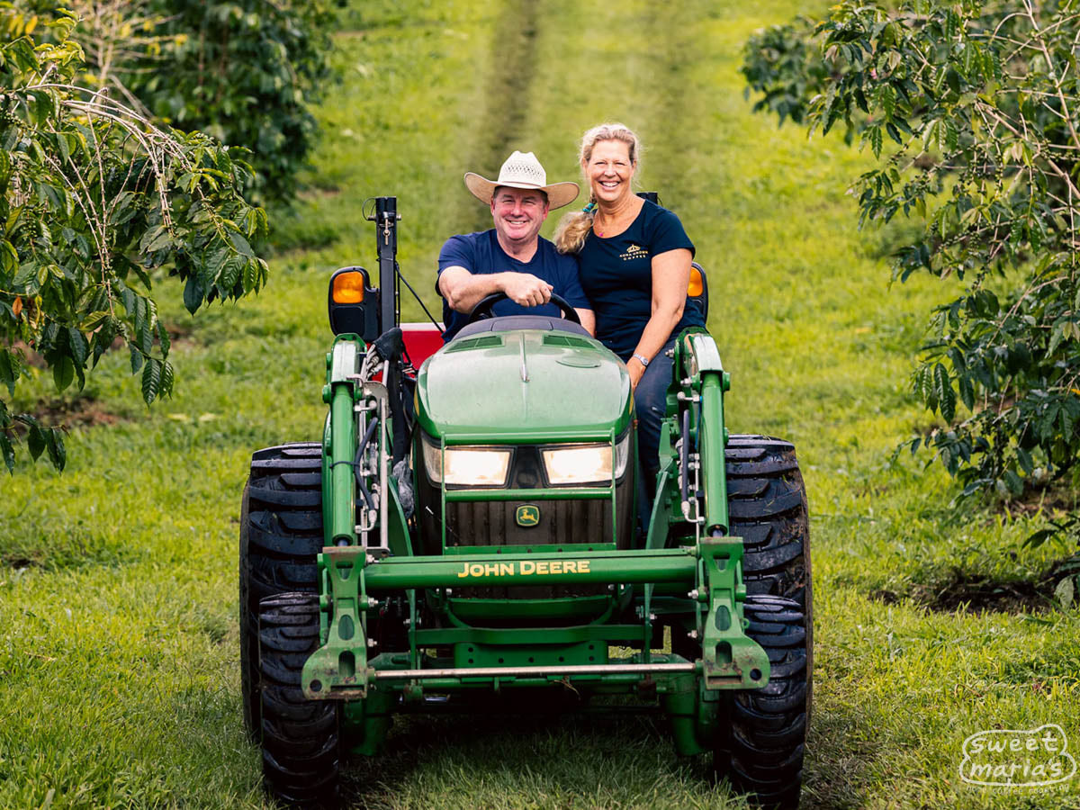 Ted and Pam Darnall pose for a photo on a John Deer tractor, at their coffee farm in Kona, Hawaii.