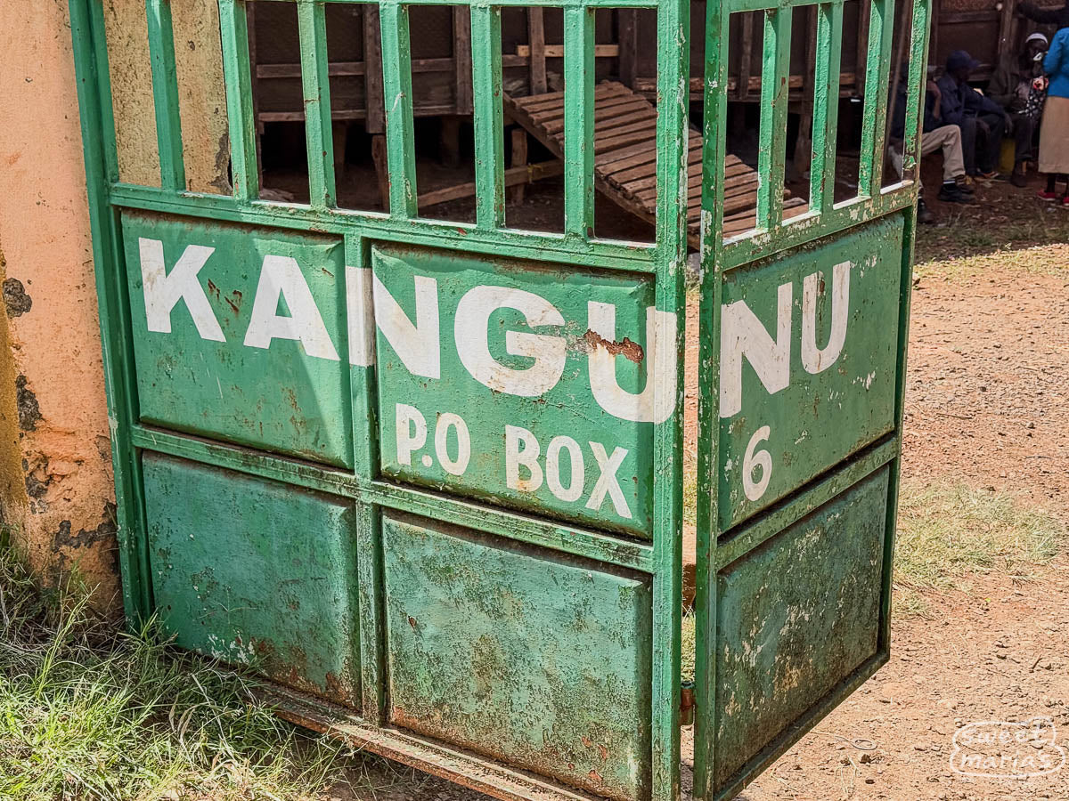 Green metal gate that reads "KANGUNU" at the entrance to the coffee factury in Muranga.