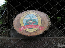 A wooden "Cafetalera Buenos Aires" sign that hangs on the fence near the entrance to the farm. Dipilto, Nicaragua.