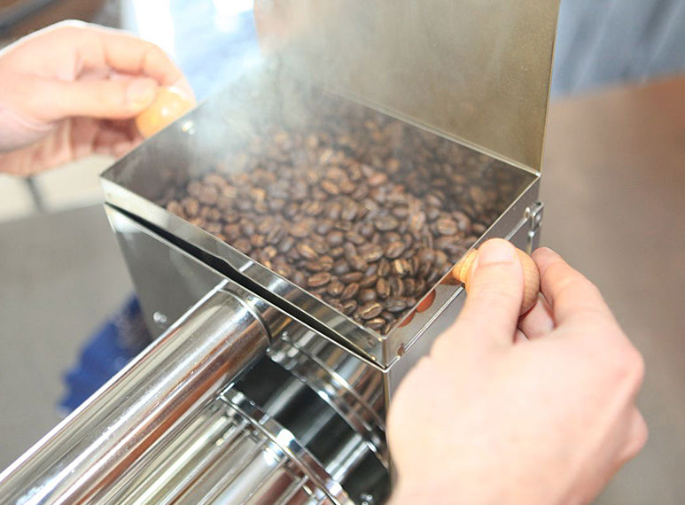 A metal chaff tray is located under the roasting drum and can be removed by pulling a wooden handle