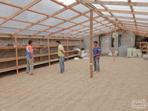 Inside one of the expansive coffee drying rooms at the Pendekar coffee cooperative, green coffee dries on raised beds, and cement patio floor below. Kerinci, Sumatra.