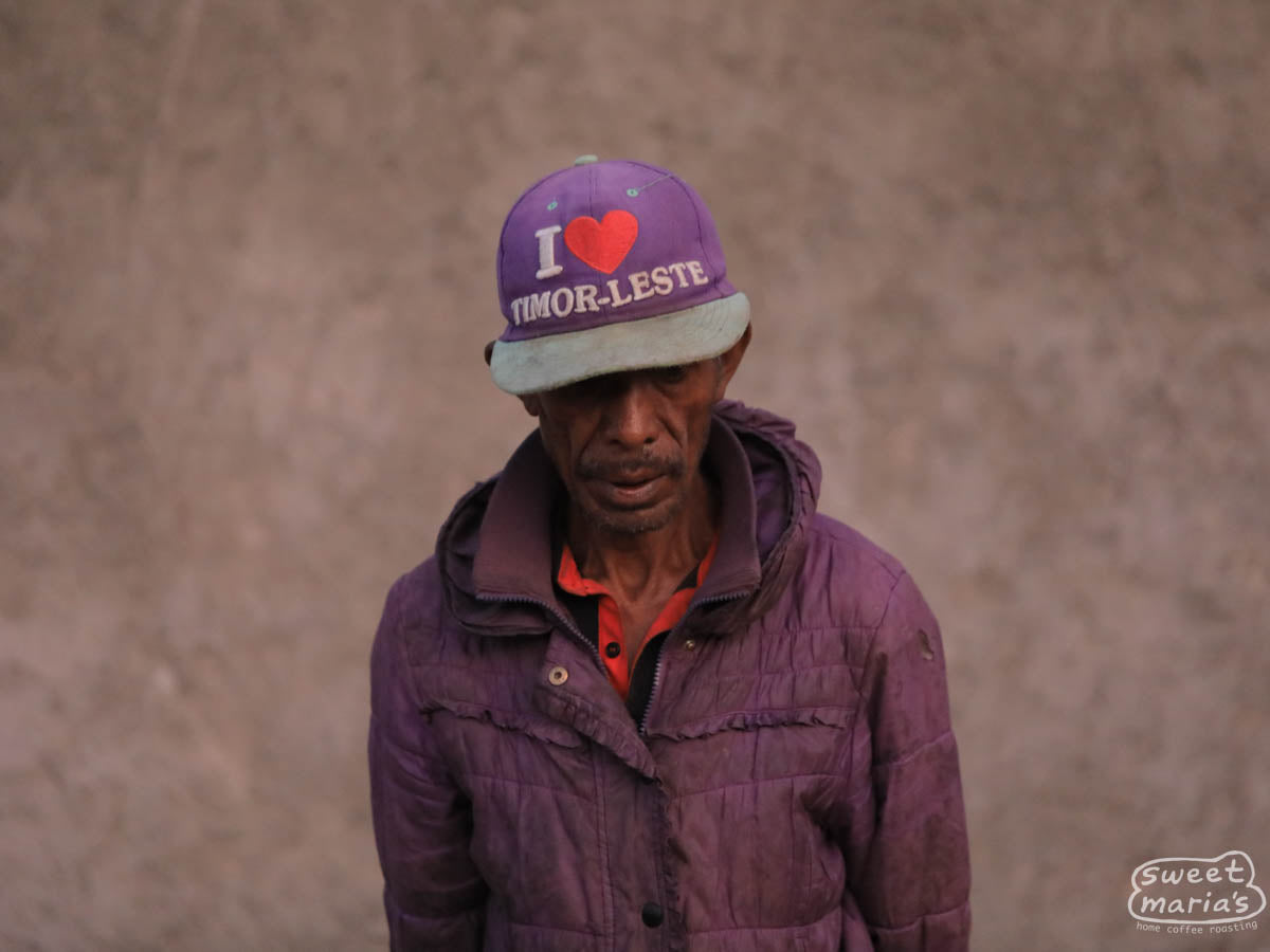 Coffee farmer wearing a purple hat that reads