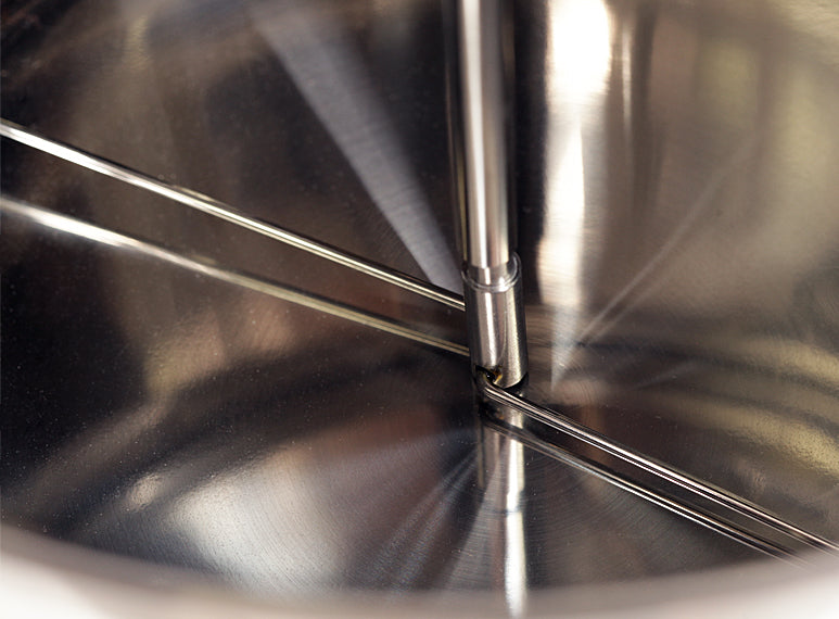 Metal arms attached to a central drive shaft stir the coffee beans throughout the roast